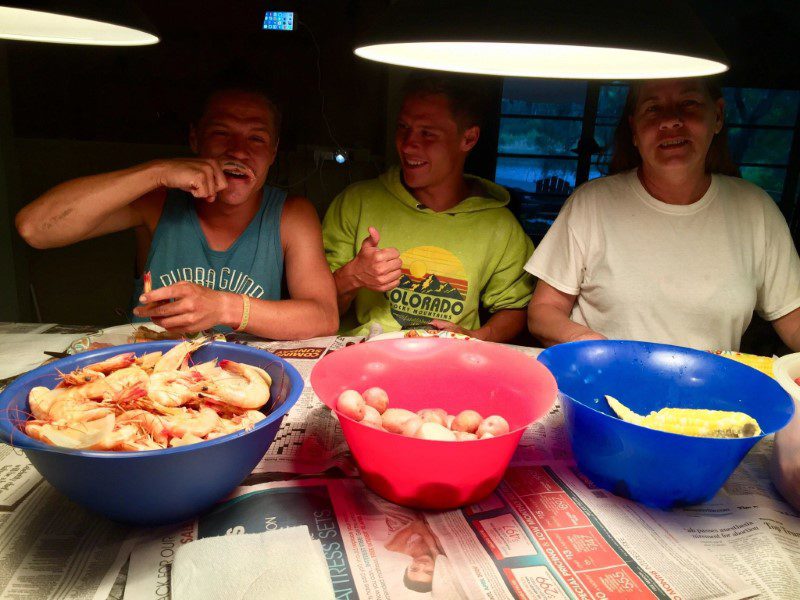 Three men sitting at a table with bowls of food.