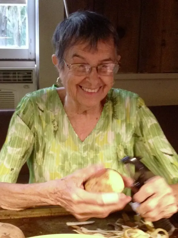 A woman holding an apple and smiling.