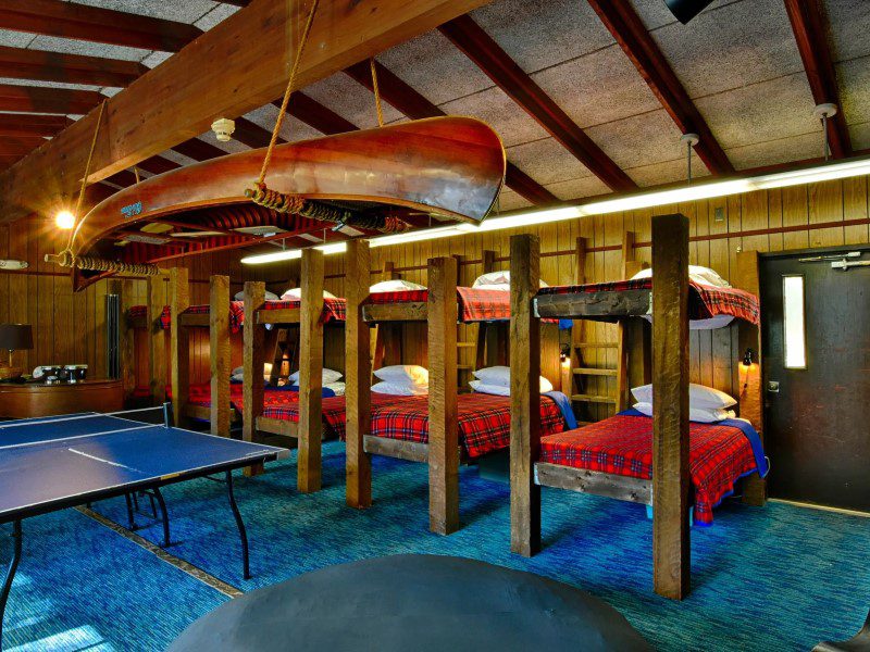 A room with many beds and tables in it