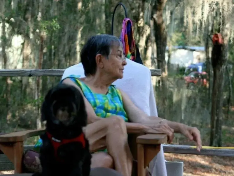 A woman sitting on a chair with her dog.