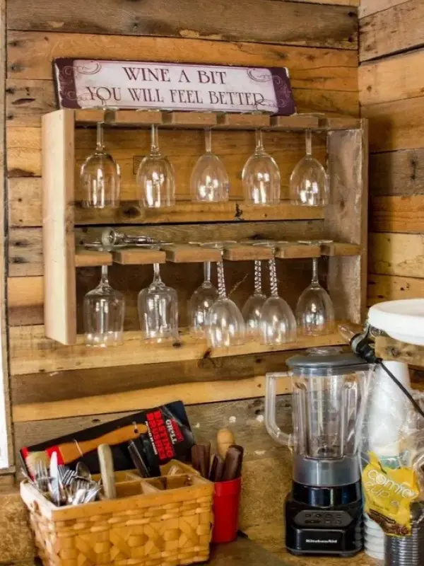 A wooden shelf with wine glasses hanging on it.