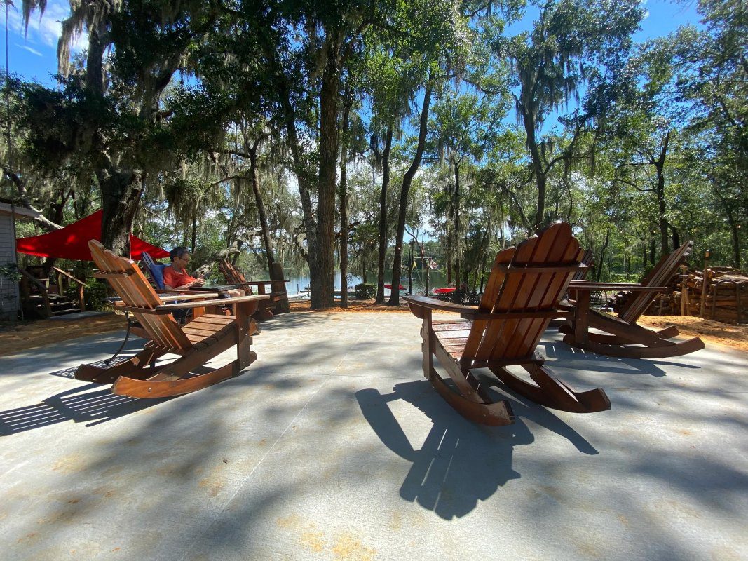 A group of wooden chairs sitting on top of cement.