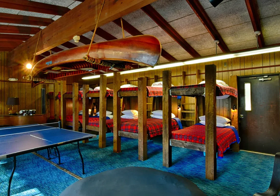 A room with several beds and tables in it